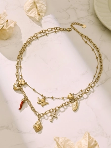 Detailed view of layered 18k gold-plated necklaces with cross and heart charms