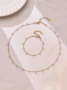 Detailansicht der vergoldeten Edelstahl-Halskette und des Armbands mit Zirkonia-Tropfen