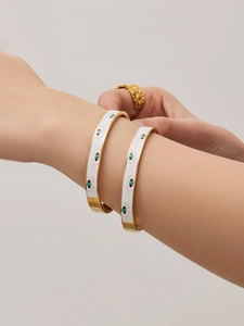 Detail of 18k gold plated bangle with white enamel evil eye and turquoise accent