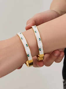 Close-up of 18k gold plated stainless steel evil eye bracelets worn on a model wrist