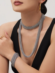 Detail van meerlaagse ketting en armband set met gepolijste zilveren afwerking