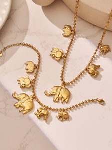 Detail van gouden olifant hangers aan de kogelketting en armband sieradenset