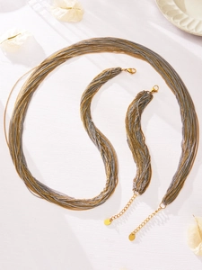 Detail van gelaagde ketting sieradenset met 18k gouden karabijnsluiting en verlengketting