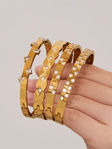 Detail of four 18k gold plated stainless steel bracelets with drop-shaped zircon accents
