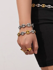 Detailopname van tweekleurige varkenssnuit-armbanden en gestapelde gouden ringen bij model