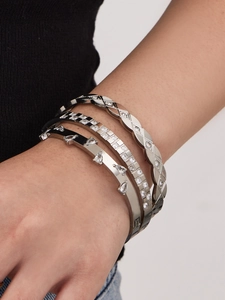 Detailed view of silver stackable bracelets with water drop zircons and geometric patterns