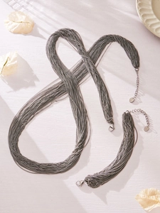 Detail van de meerlaagse donkergrijze metalen ketting- en armbandset met karabijnsluiting