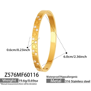 Detailed view of 18k gold-plated bangle with engraved flowers and cubic zirconia stones