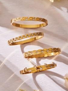 Detail of four luxury 18k gold plated stainless steel bangles with zircon settings
