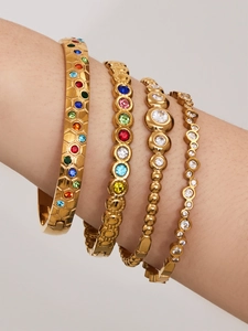 Nahaufnahme von 18 Karat vergoldeten geometrischen Armbändern mit bunten Zirkonsteinen