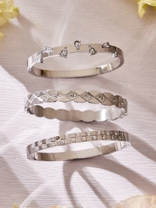 Detailed view of silver finish bracelets featuring pear-shaped zircon and geometric patterns