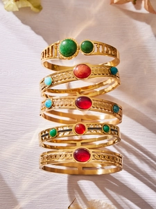 Dettaglio di cinque bracciali vintage placcati in oro con gemme colorate assortite
