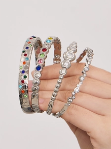 Makroaufnahme von versilberten Armbändern mit bunten Edelsteinen und Zirkonia-Inlays