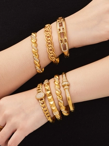 Detail of 18k gold plated geometric bracelets with cubic zirconia on black fabric