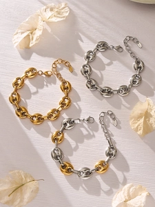 Detail van koffieboon schakelarmbanden in goud, zilver en tweekleurig roestvrij staal