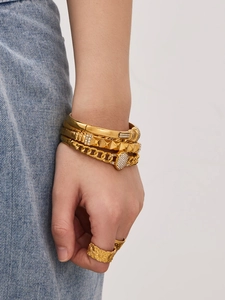 Close-up of gold plated stainless steel bangles set with zircons on a female wrist