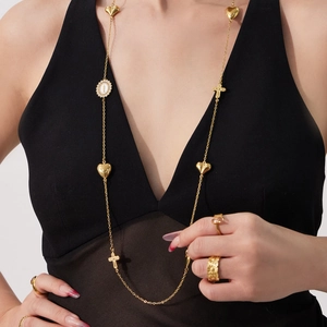 Gouden dubbellaagse trui-ketting met hartjes, een kruis en een religieuze ovale medaille