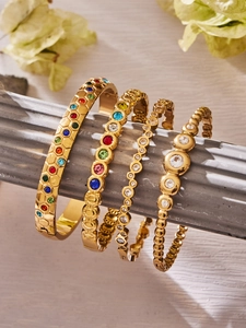 Detailansicht von vier 18k vergoldeten Armbändern mit bunten Zirkonsteinen und Wabenmuster