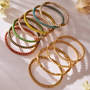 Bunte Emaille-Armreifen und goldbeschichtete Perlenarmbänder mit Zirkonia-Steinen