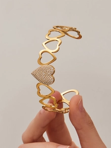 Detail of gold-plated heart bracelet with white zircon inlay and mirror-polished finish