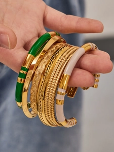 Macro shot of 5pcs gold cuff bracelets featuring green enamel and wheat textures