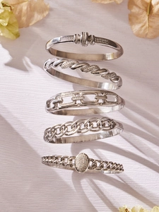 Détail de cinq bracelets en acier inoxydable argenté avec incrustations de zircon