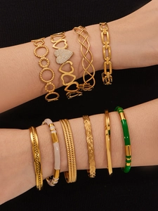 Close-up of stylish gold-plated bangles and zircon bracelets set on a model arm
