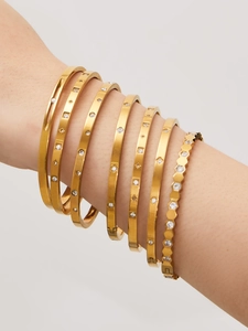 Makroaufnahme von 18k vergoldeten Edelstahl-Armbändern mit Waben- und Sternenmotiven