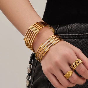 Goldenes durchbrochenes Manschettenarmband mit Zirkoniasteinen im breiten Mehrschicht-Design