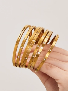 Detail von 18k vergoldeten Edelstahlarmbändern mit Zirkonia und Sternmustern