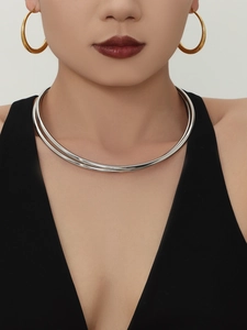 Vista dettagliata di un girocollo minimalista in acciaio inossidabile argento su modella