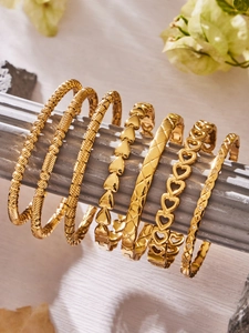 Dettaglio del set di braccialetti geometrici placcati in oro 18k con design a cuore