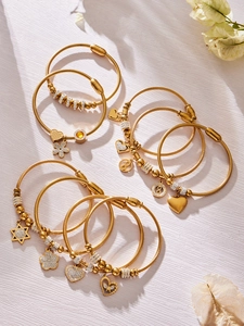 Dettaglio di bracciali in acciaio inossidabile placcato oro 18k con ciondoli zircone