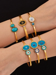 Gros plan de bracelets œil protecteur dorés avec turquoises et étoiles sur poignet mannequin