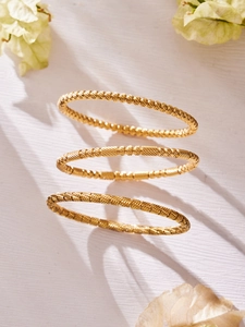 Dettaglio di tre bracciali in acciaio inossidabile placcati oro 18k con diverse trame