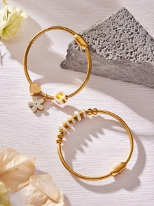 Dettaglio del bracciale placcato oro 18k con ciondoli in zircone e cuore su roccia lavica