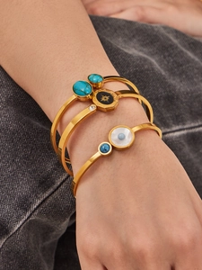 Détail de trois bracelets dorés bohèmes avec turquoise, émail noir et nacre blanche