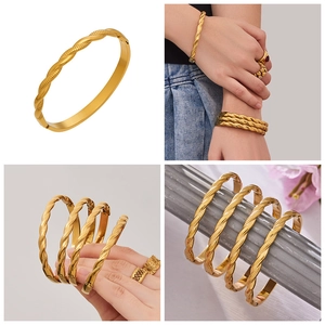 Vista detallada del brazalete trenzado bañado en oro de 18k y el anillo floral con bisagra