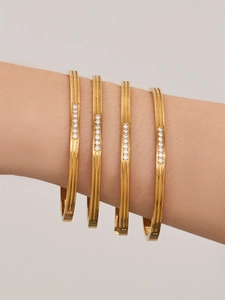 Detailed view of stacked 18k gold plated stainless steel bangles with micro-pave zircon