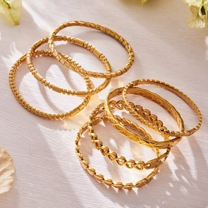 Set of 18k gold plated stainless steel geometric bangles featuring heart and twisted patterns
