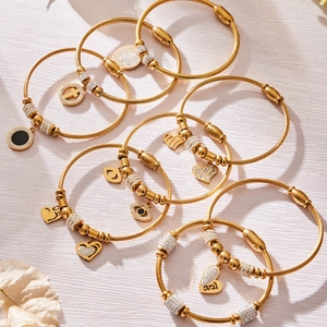 Goldenes Edelstahl-Armreif-Set mit Zirkonia-Anhängern wie Kreuz und Herzmotiven