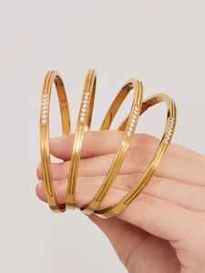 Detail of 18k gold plated stainless steel bangles with zircon inlay on model hand