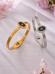 Détail macro de bracelets or et argent avec gravures d'étoiles et zircons transparents
