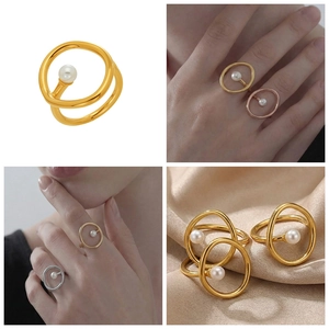 Detail eines 18 Karat vergoldeten Rings mit Perle auf champagnerfarbenem Seidenhintergrund