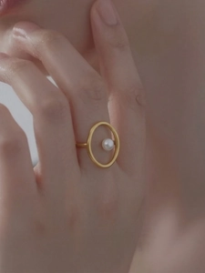 Nahaufnahme eines minimalistischen 18k vergoldeten Rings mit einer eleganten weißen Perle