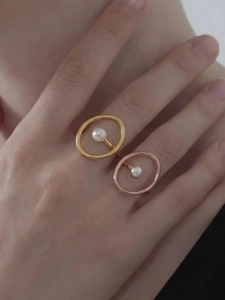 Detail eines 18k vergoldeten ovalen Rings mit schwebender Perle an der Hand