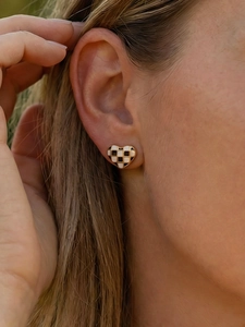 Gros plan d'une boucle d'oreille cœur en damier noir et blanc sur un mannequin