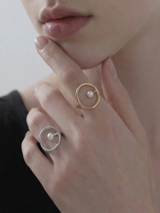 Nahaufnahme minimalistischer 18k Gold- und Silberringe mit Perlen auf einer Hand