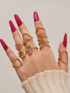 Macro detail of 10-piece gold geometric ring set with heart and floral patterns