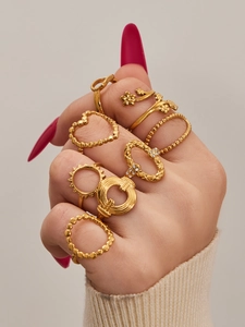 Close-up of gold geometric heart rings set with various patterns on model hand